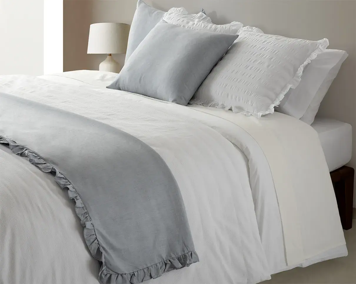 Softly layered grey and white bed linen